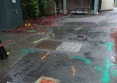 Colored marks on path show where existing utilities are located.
